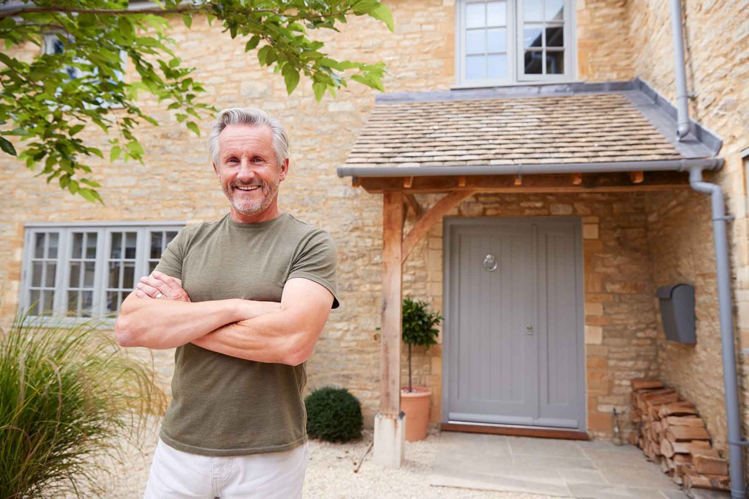 portrait-of-senior-man-standing-outside-front-door-TGQK9MH.jpg